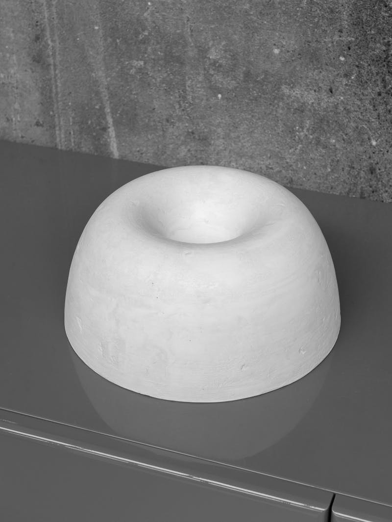 Colour image displaying top-view of 'Twirl Bowl' in white from ongoing collection 'Twirl Bowls' by Lenny Stöpp. The bowl is moulded from alpha crystalline gypsum using the cornice vessel technique. This item is part of the new 2024 spring collection 'Observations' by online gallery Metamorphoses Objects.
