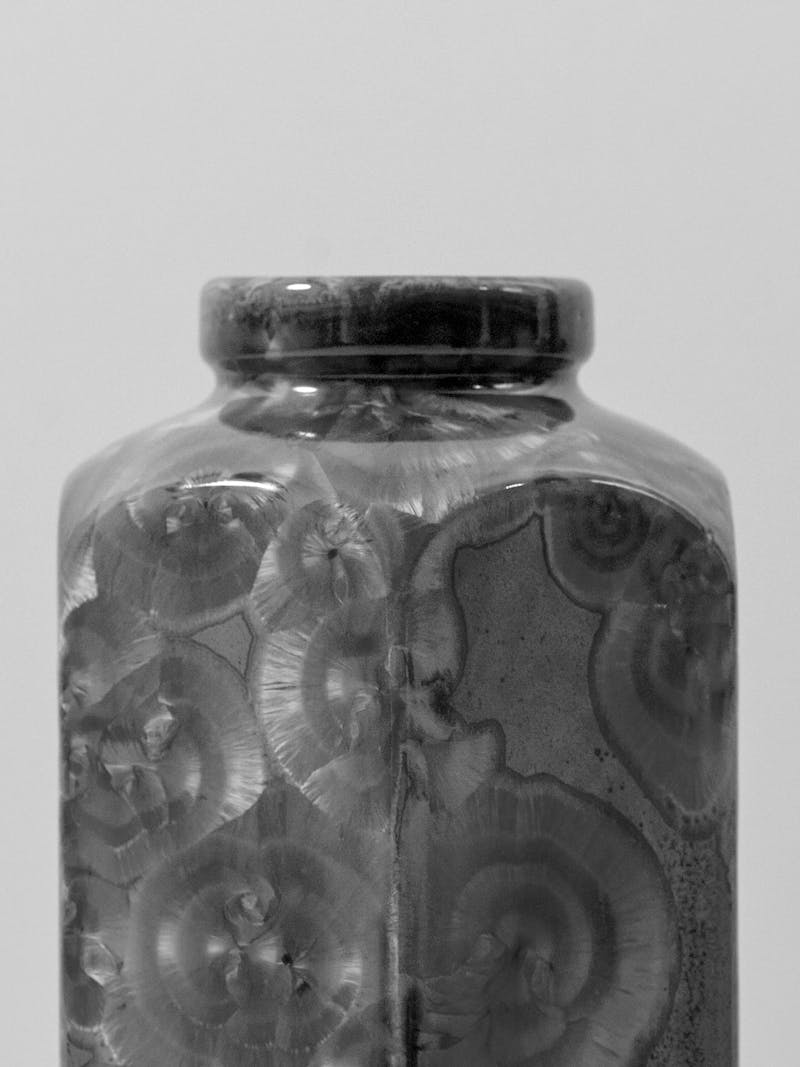 A detail image of a  hexagonal vase with a crystalline glaze, the image is in black and white and the vase is from the Czech artist Milan Pekar.
