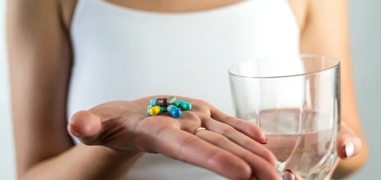 A lady holding weight-loss pills (Phentermine and Adderall)