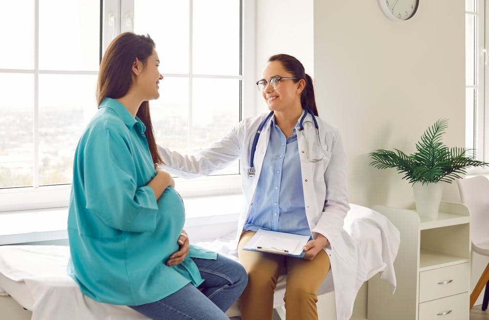 Doctor performing pregnancy consultation