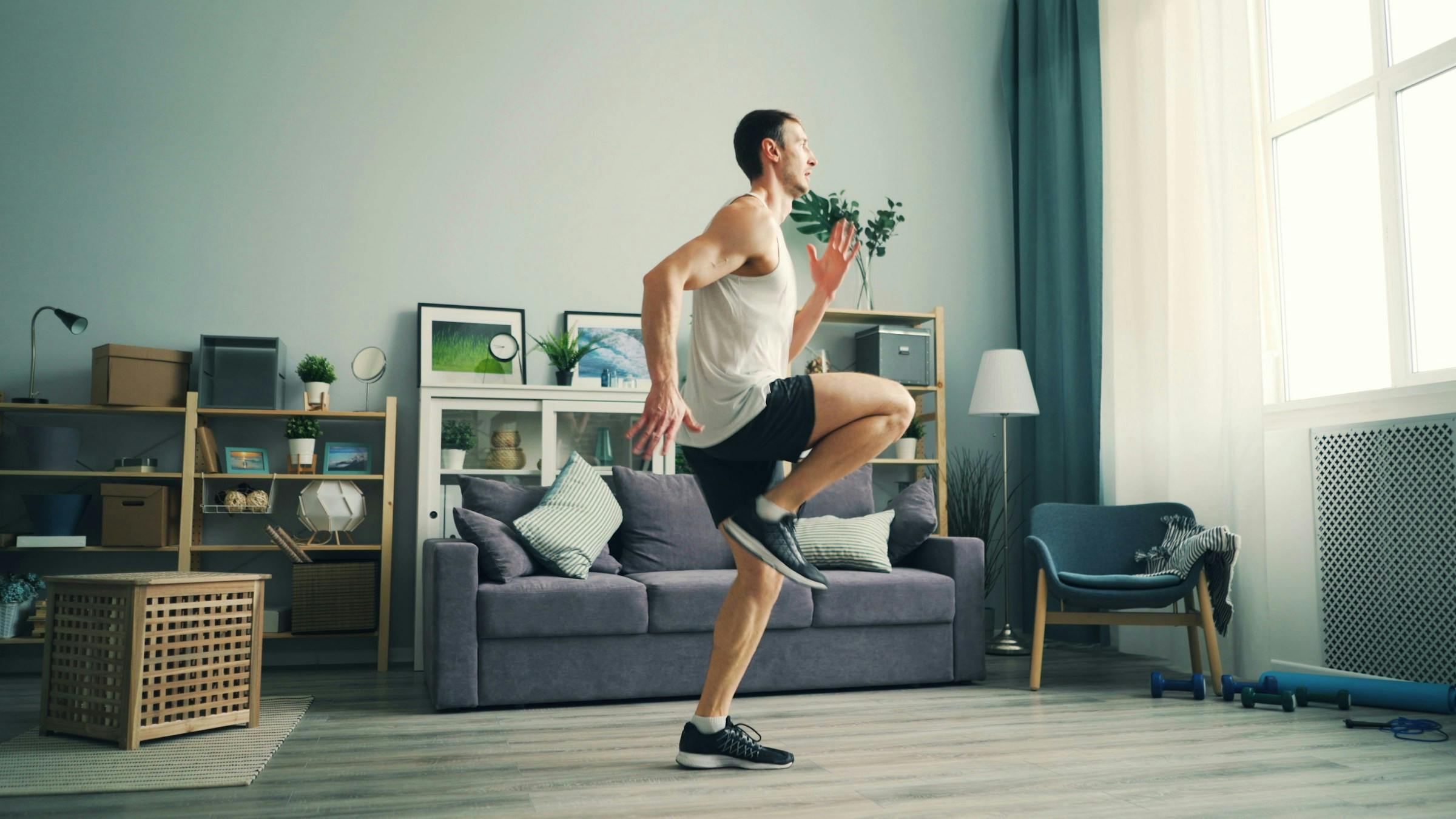 Man doing high knees for cardio workout at home