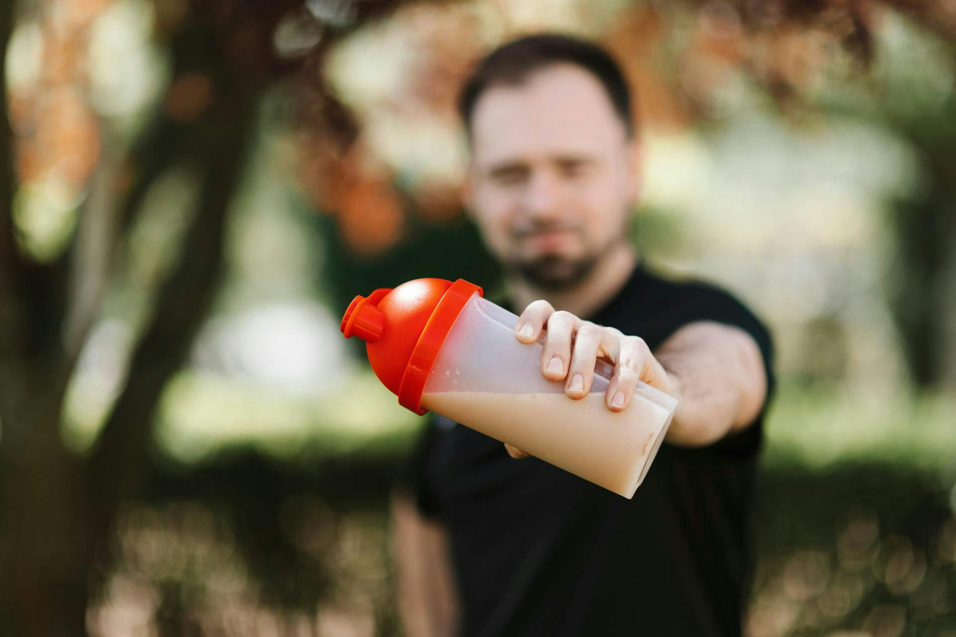Man holding a bottle of creatine