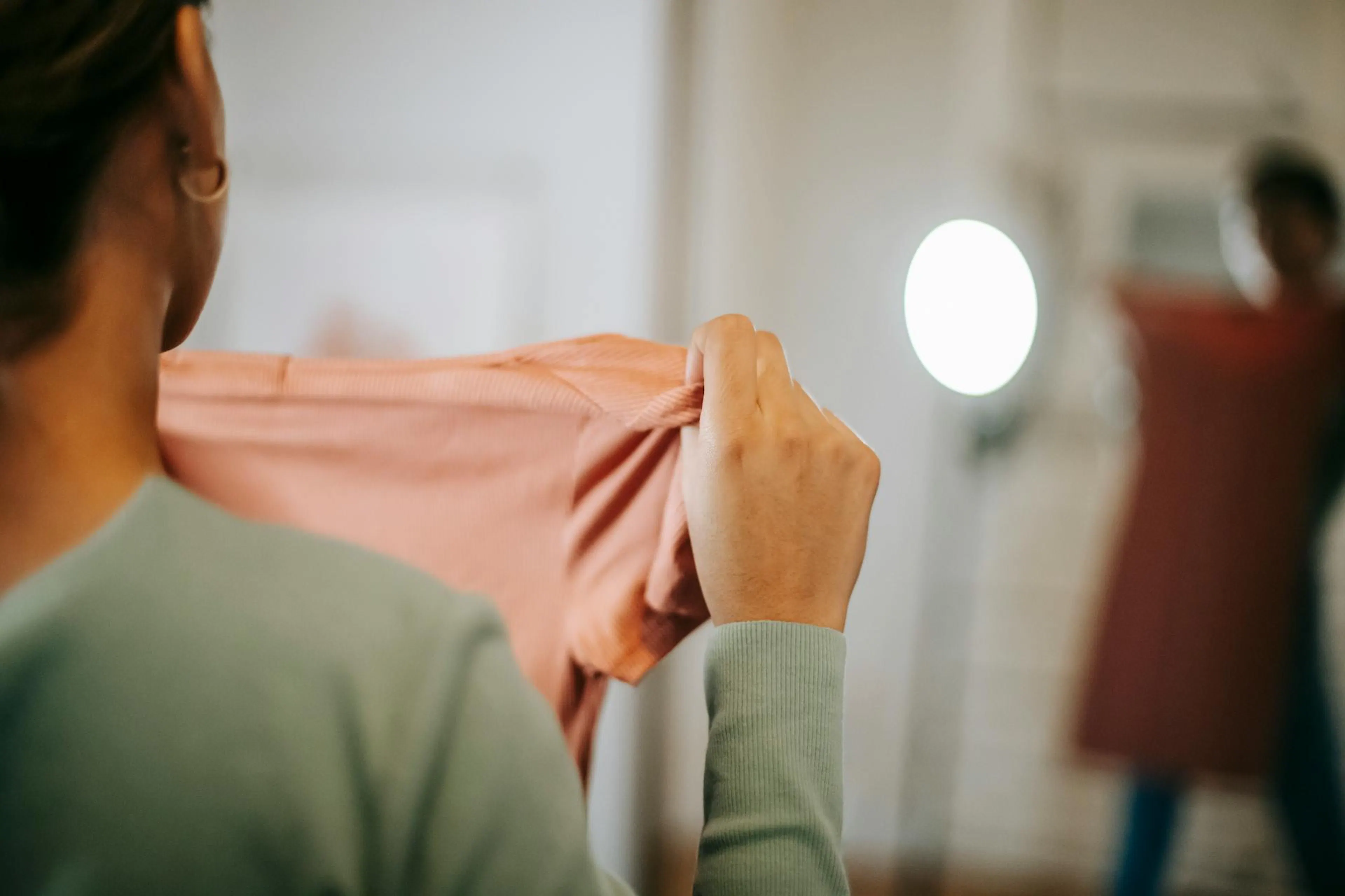 A woman sizing her clothes to measure her weight loss journey