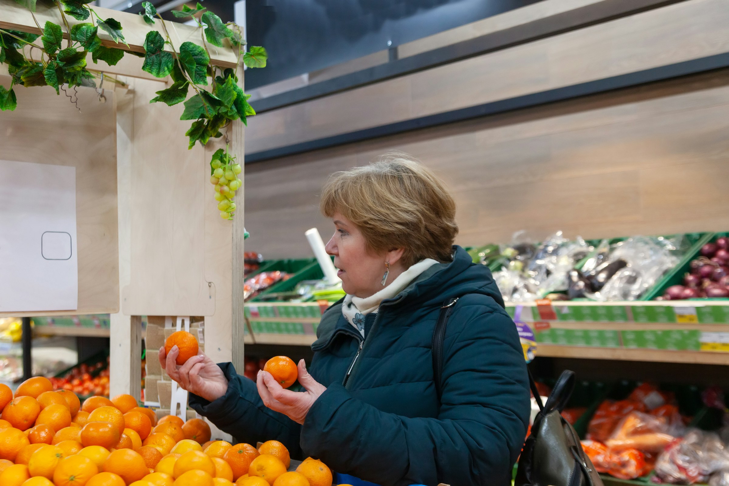 Woman choosing between clementine and mandarin at a market