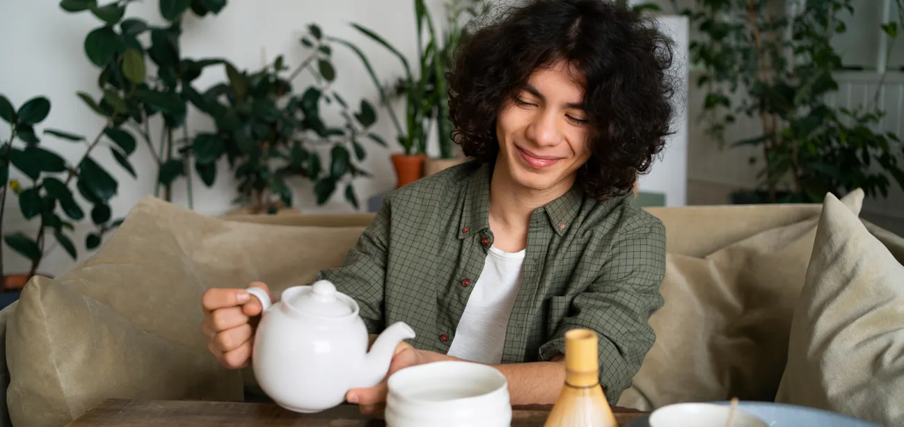 A person pouring a cup of brewed green tea for weight loss