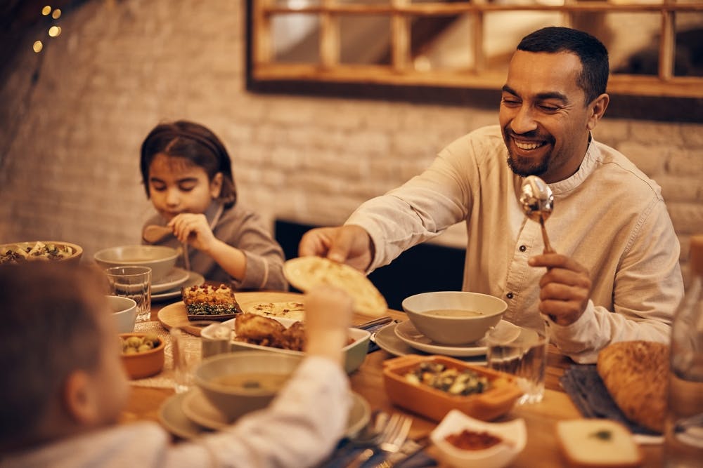 Family having whole wheat pita bread with grilled vegetables