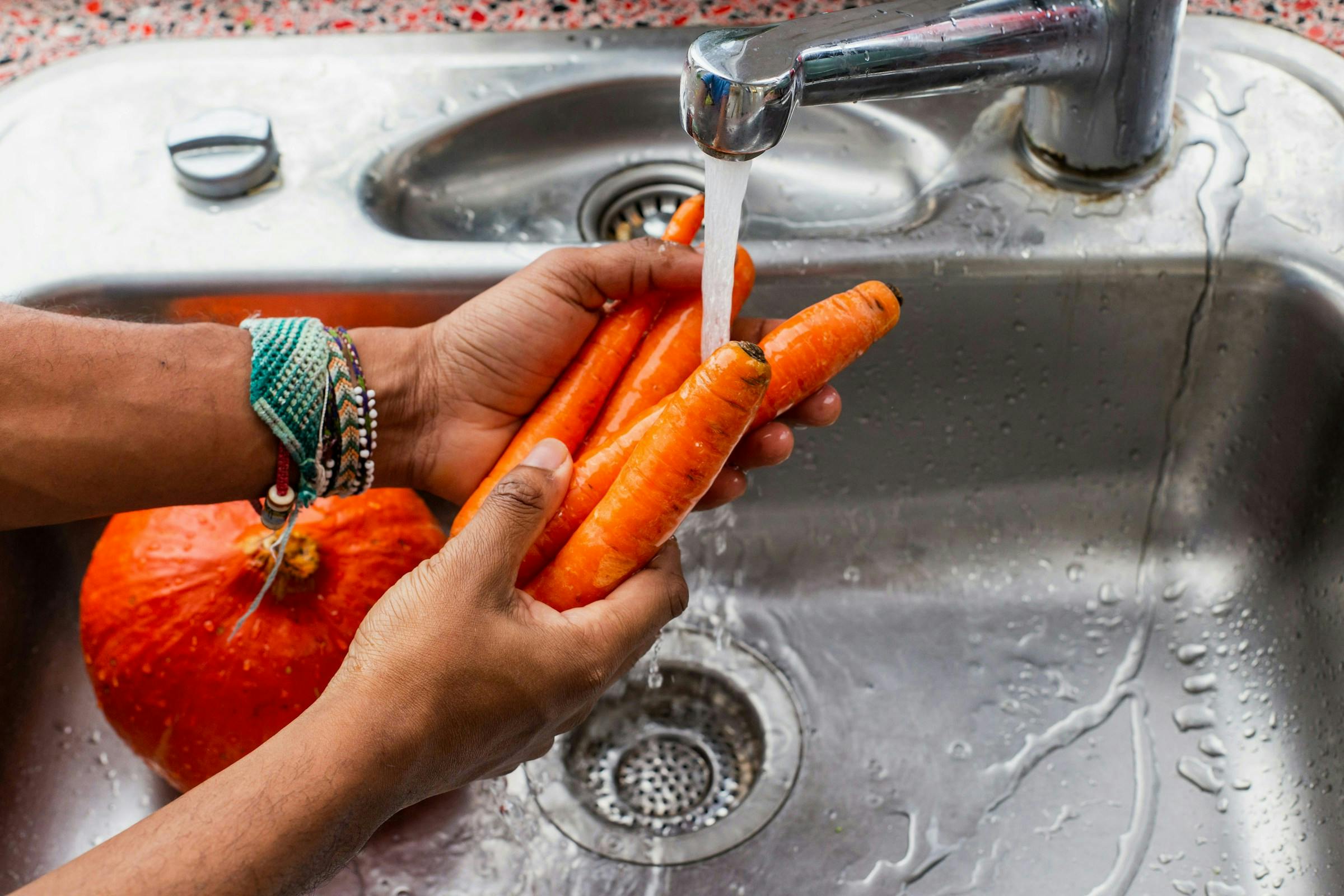 Fresh raw carrots being washed for a diabetic diet friendly meal