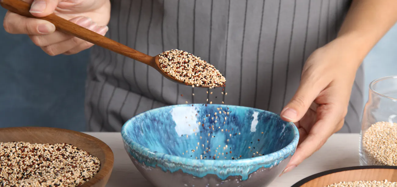 A Woman measuring quinoa as part of a healthy weight loss diet plan