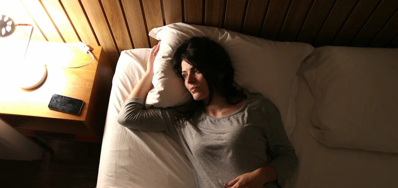 Person lying awake in bed at night