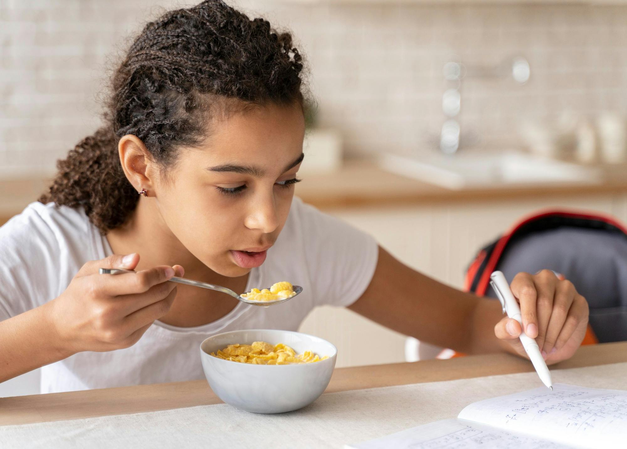A child eating a bowl of red lentils with cooked vegetables for easier digestion