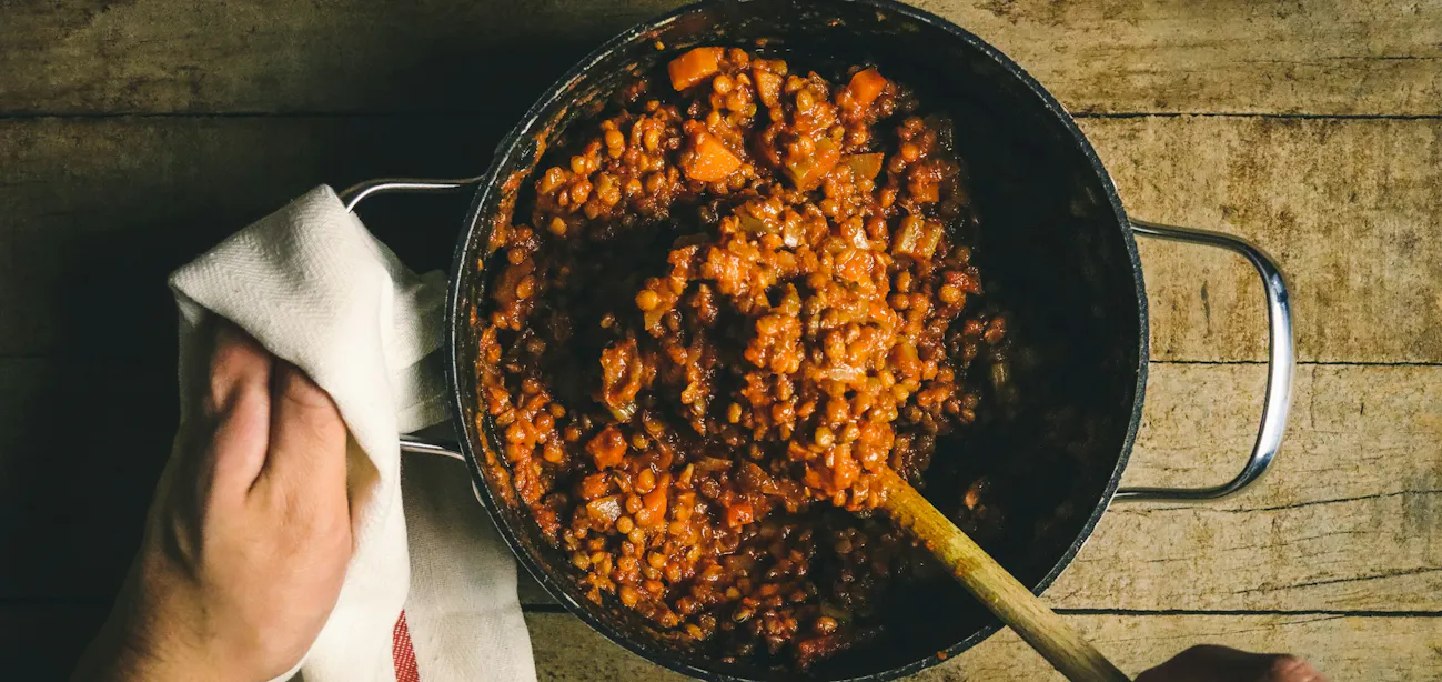 Cooked beans served with leafy greens for gut-soothing support