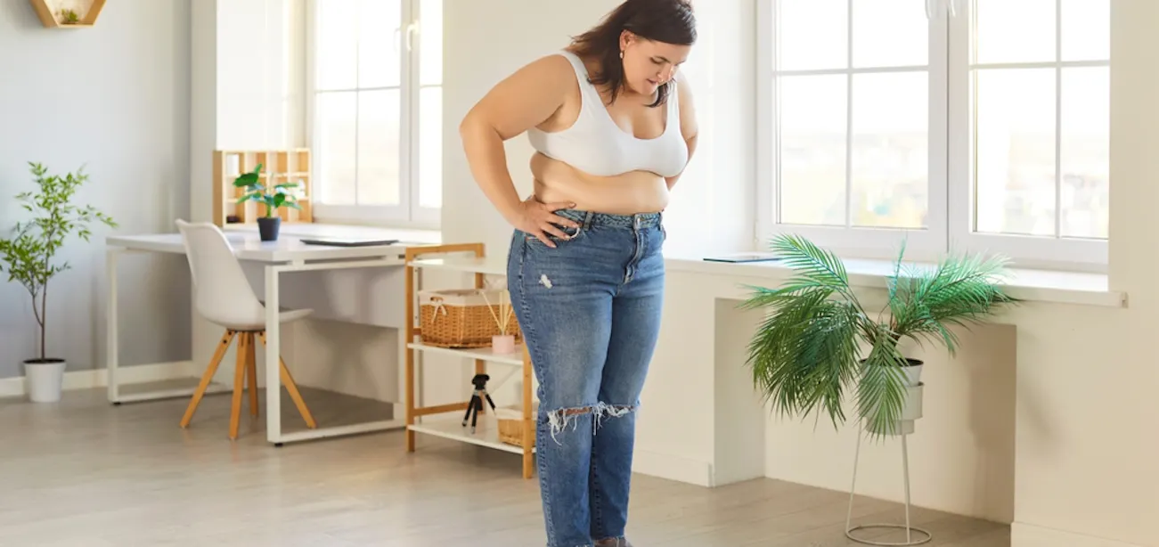 Woman frustrated about weight gain despite low food intake, symbolizing hidden causes like stress, hormones, and slow metabolism.