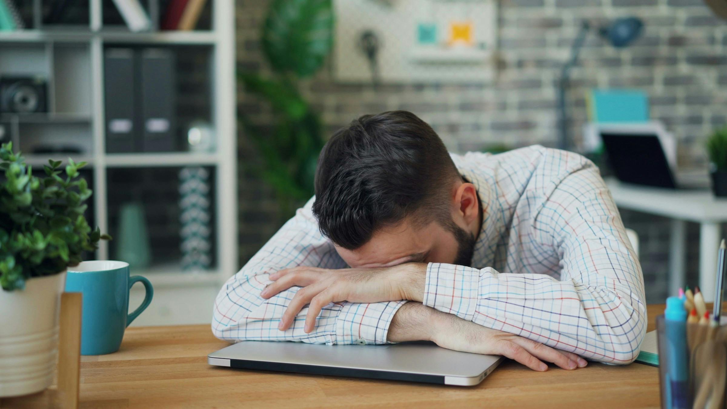A man feeling very stressed out from working