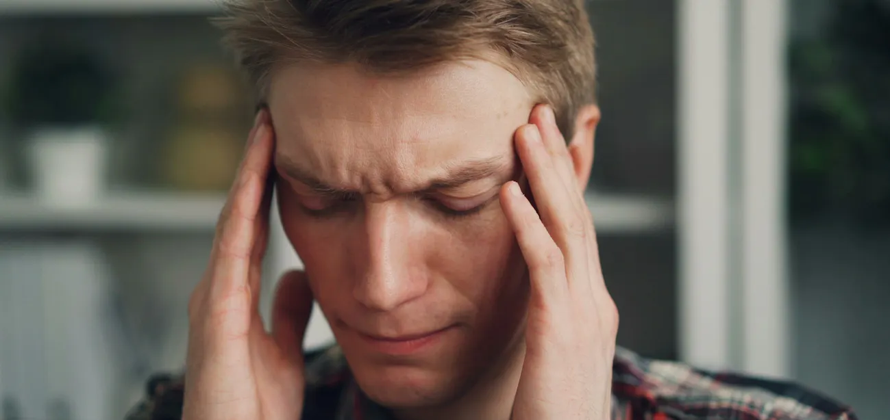 A man experiencing a pounding headache due to low blood sugar