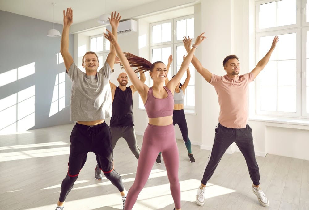 Group of people doing jumping jacks to burn calories