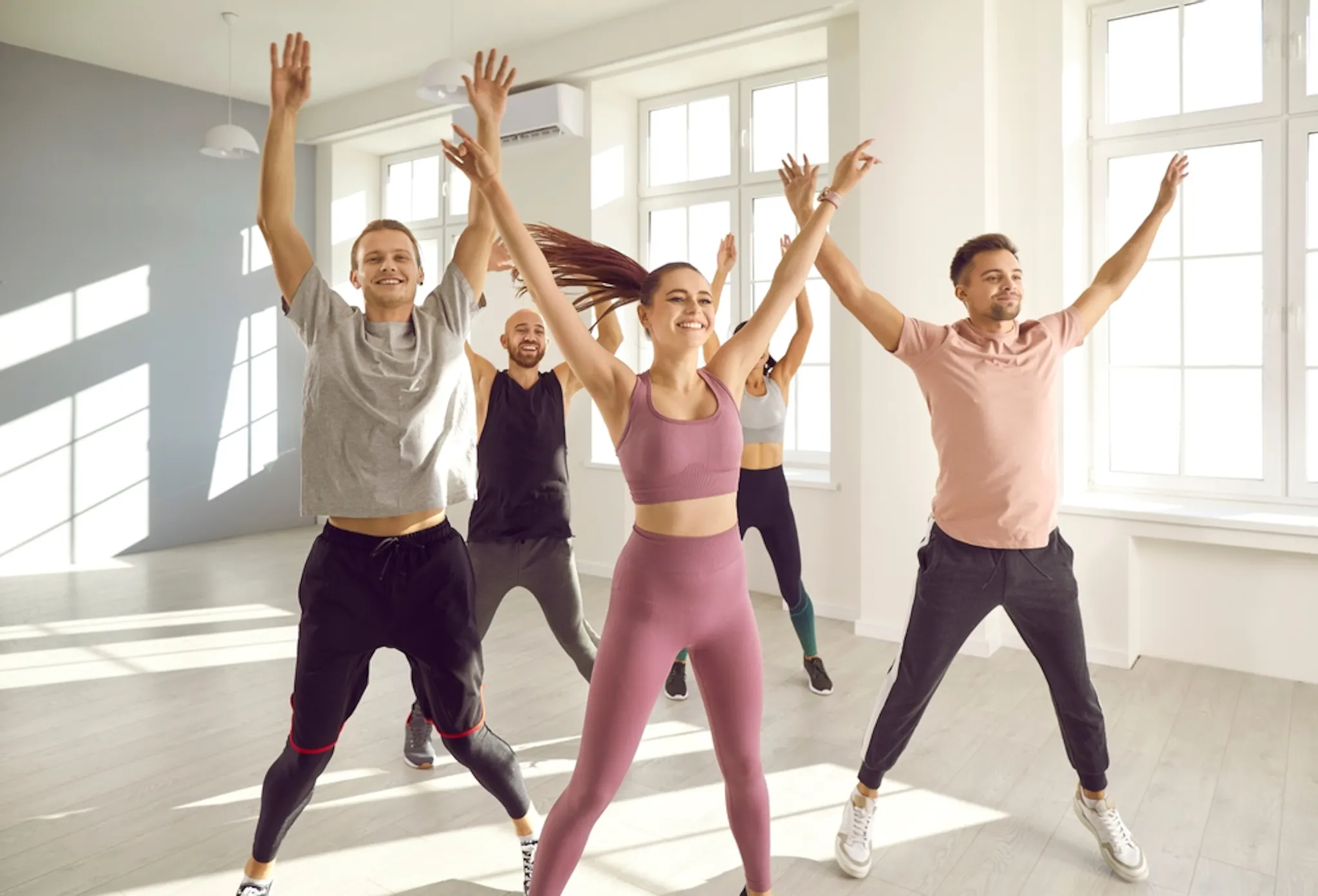 Group of people doing jumping jacks to burn calories
