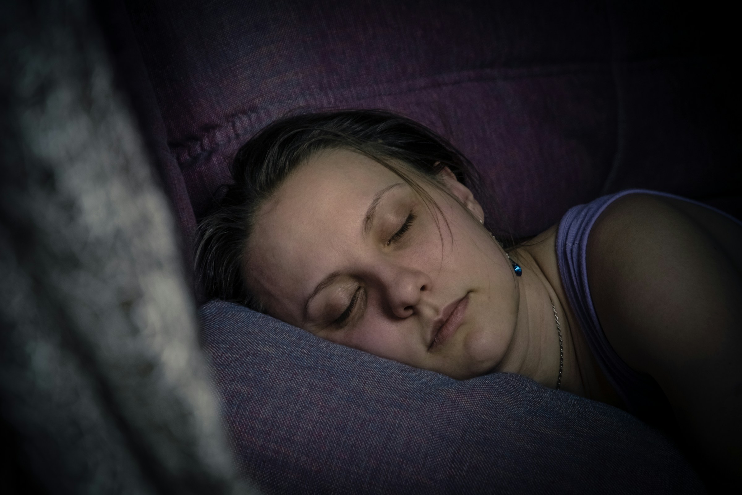 Person sleeping peacefully in a dark bedroom