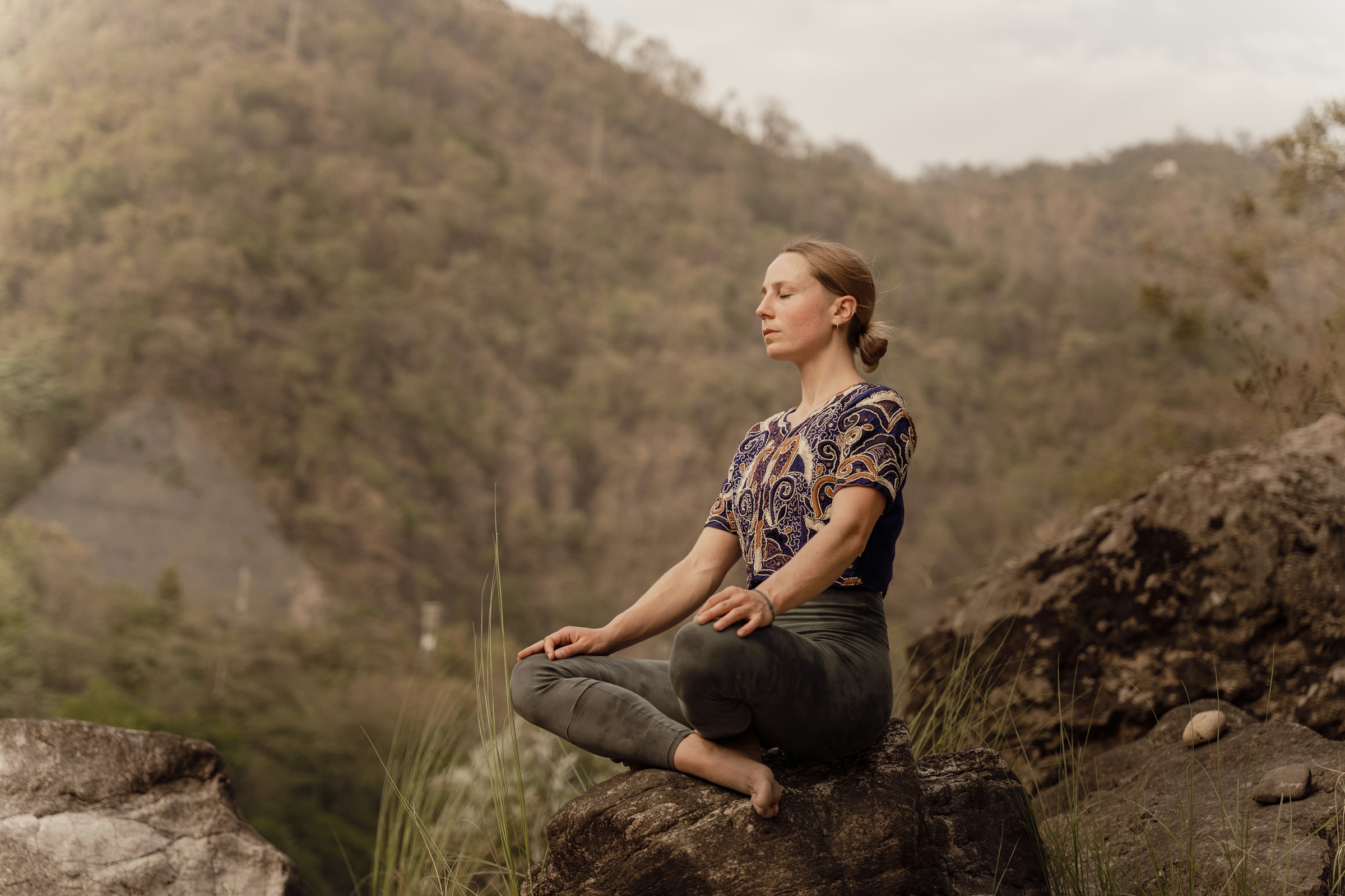 Woman meditating in nature to reduce stress and reverse aging