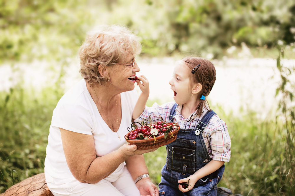 Grandma eating berries containing pterostilbene with her granddaughter
