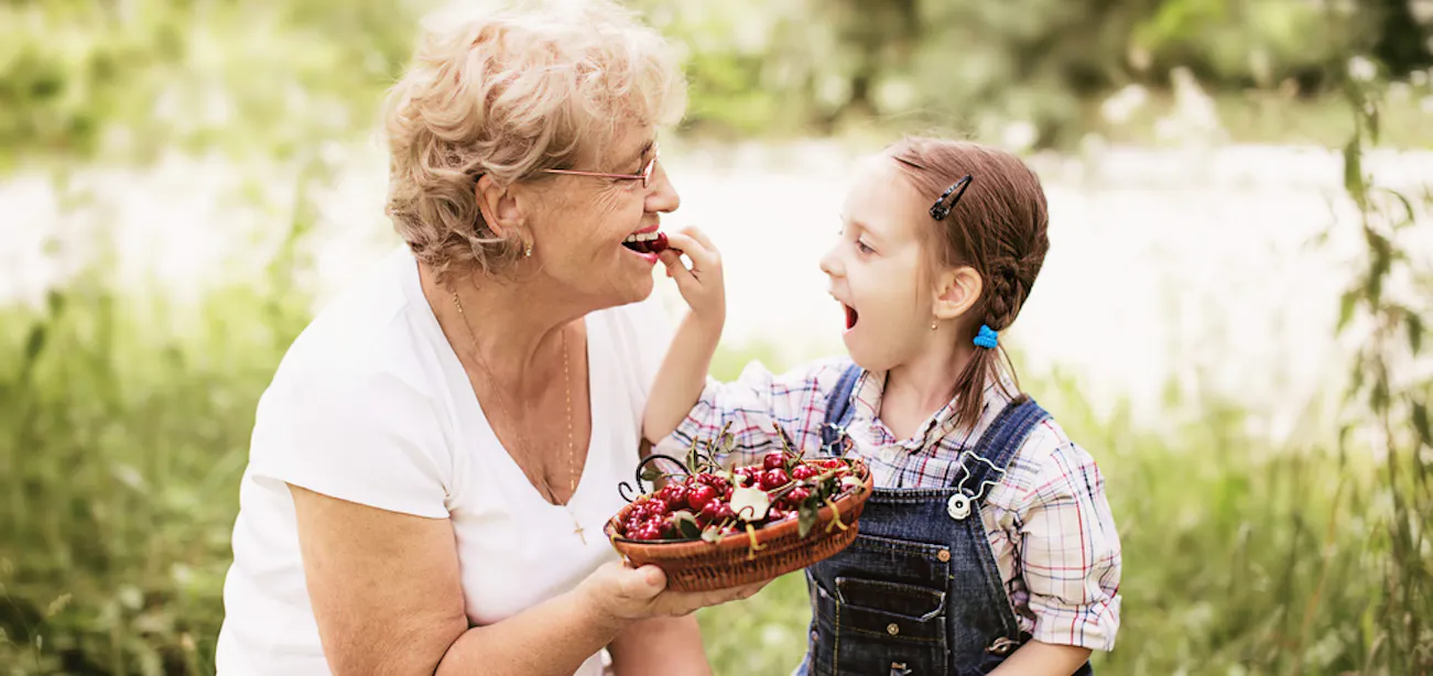 Grandma eating berries containing pterostilbene with her granddaughter