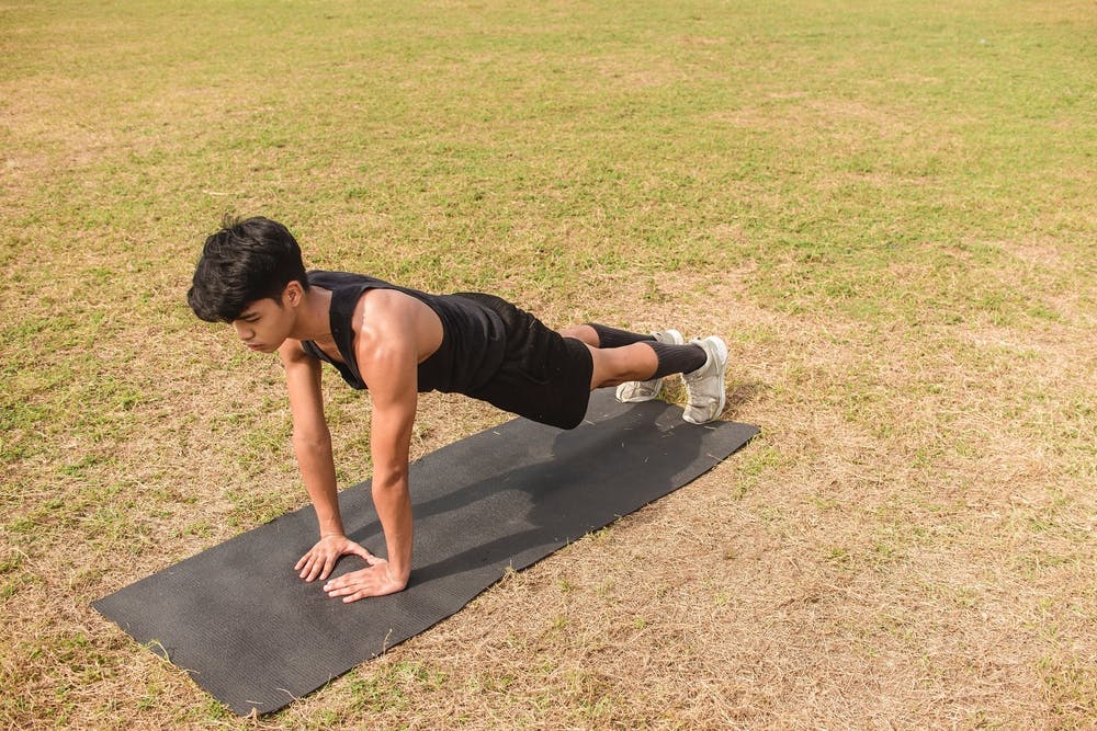 Young man doing diamond pushups for tricep build
