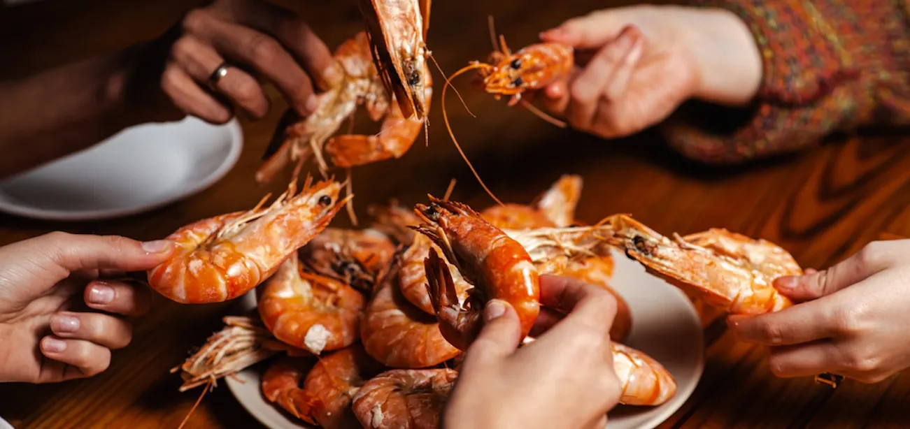 Cooked shrimp on plate with lemon and herbs