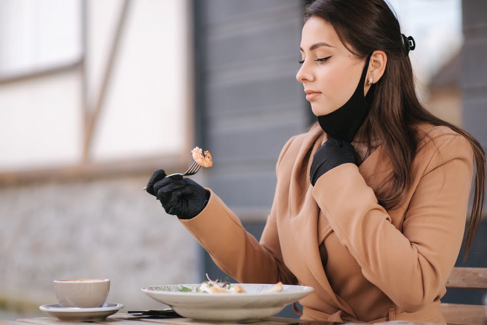 A lady eating heart-healthy shrimp
