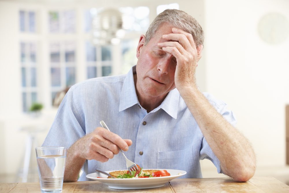 An old man experiencing increased heart rate during a meal