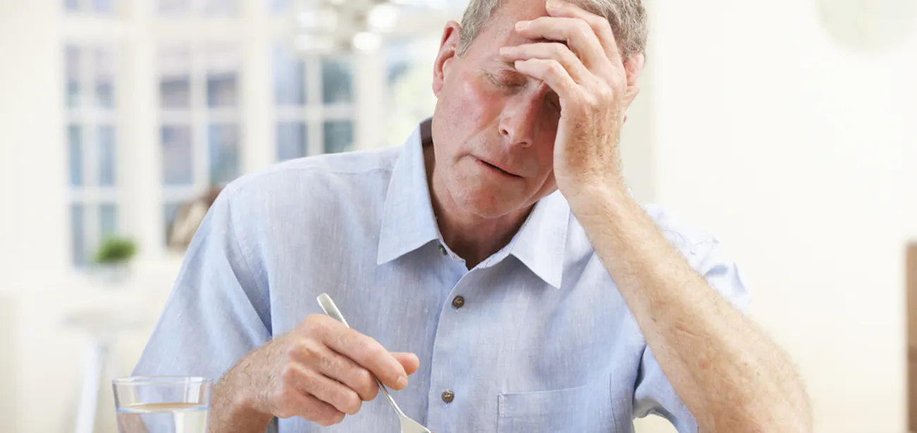 An old man experiencing increased heart rate during a meal