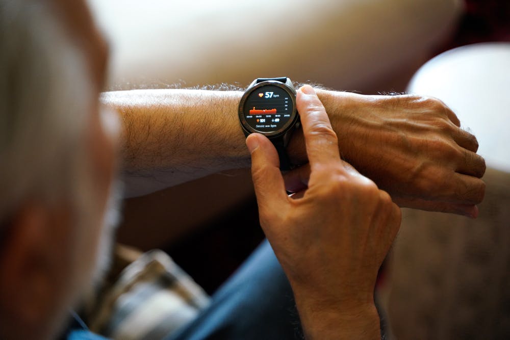 Person checking their Continuous glucose monitor with smartwatch heart rate data