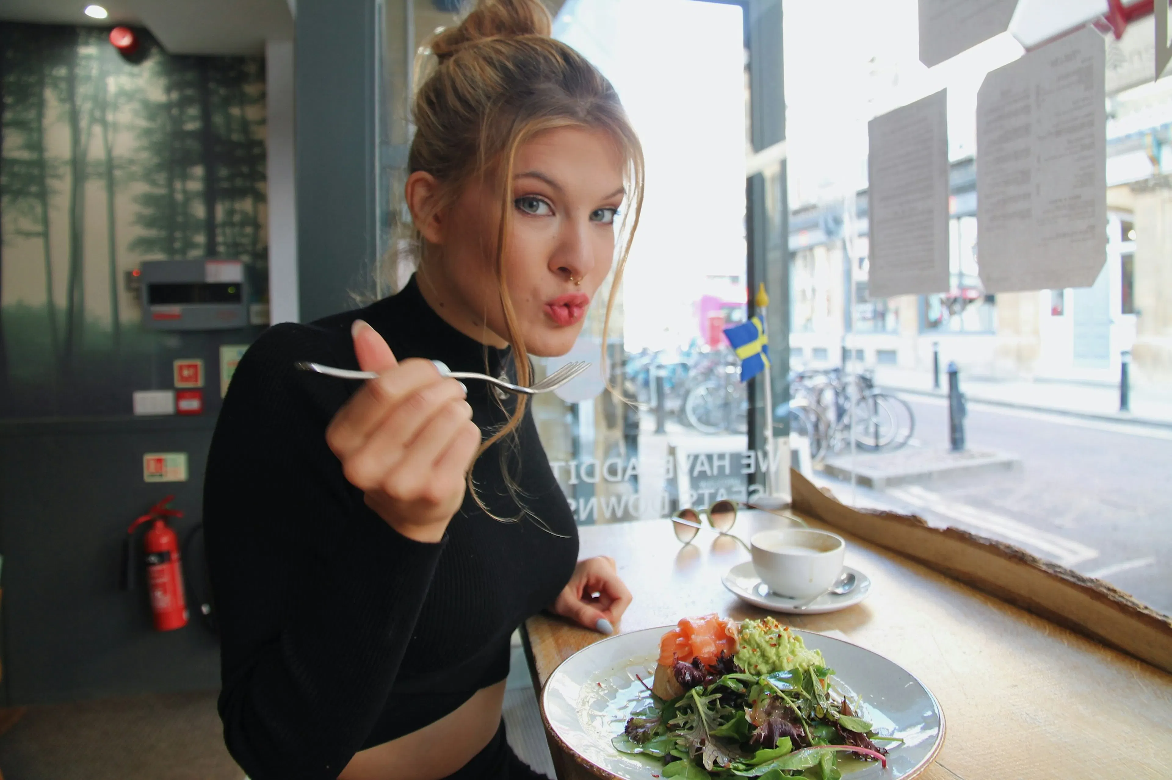 A lady eating Avocado toast with eggs at a brunch café