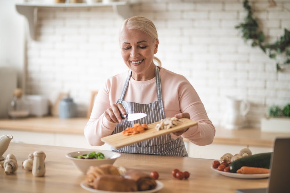 An older lady making salads with carotenoid rich food