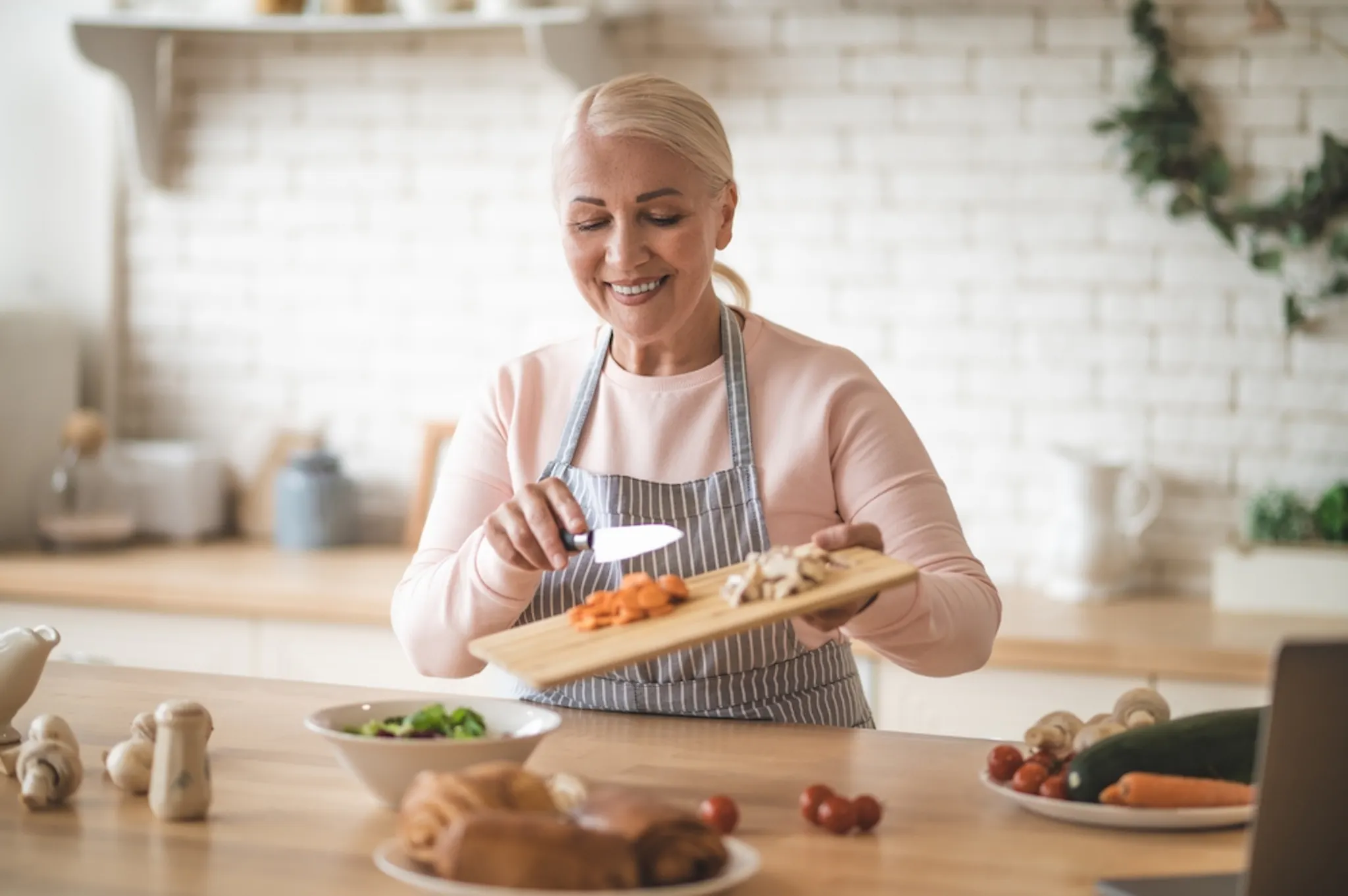 An older lady making salads with carotenoid rich food