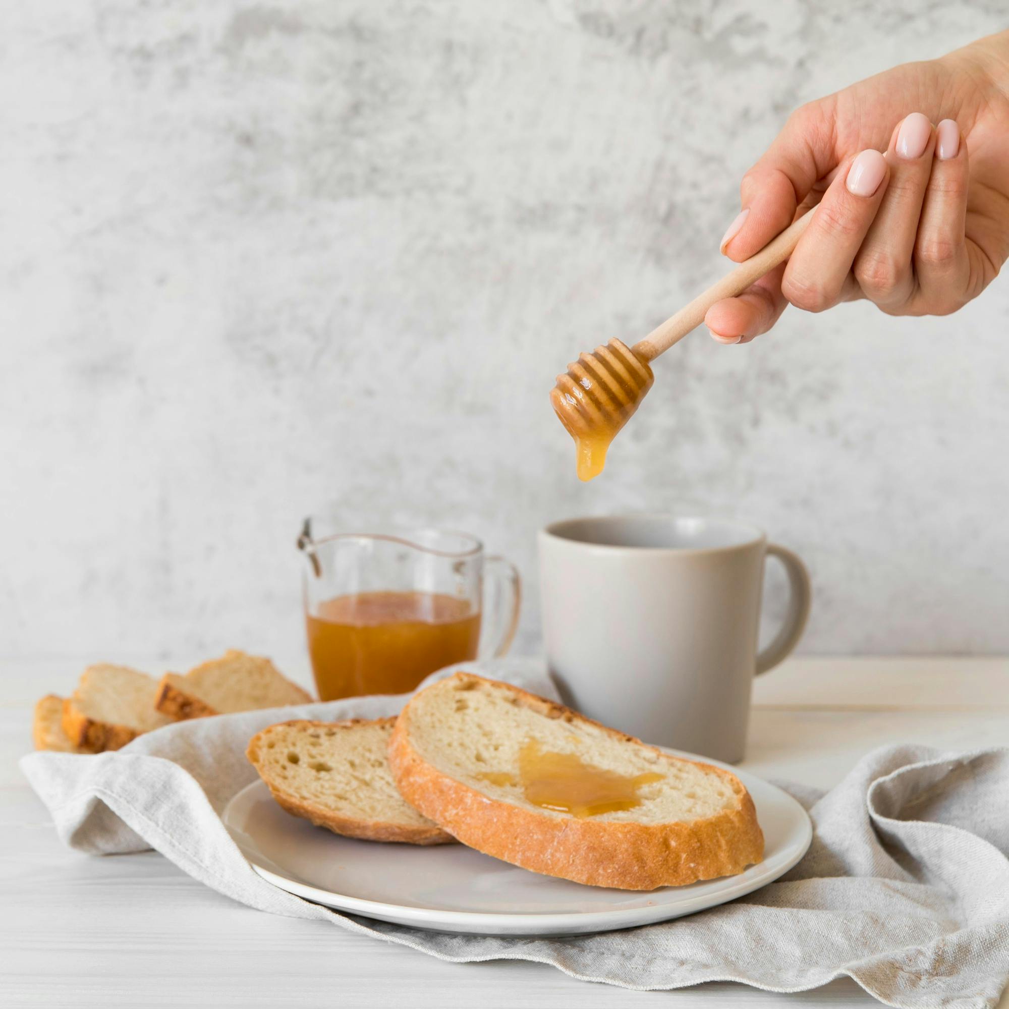 Person using honey as a good alternative to high fructose corn syrup