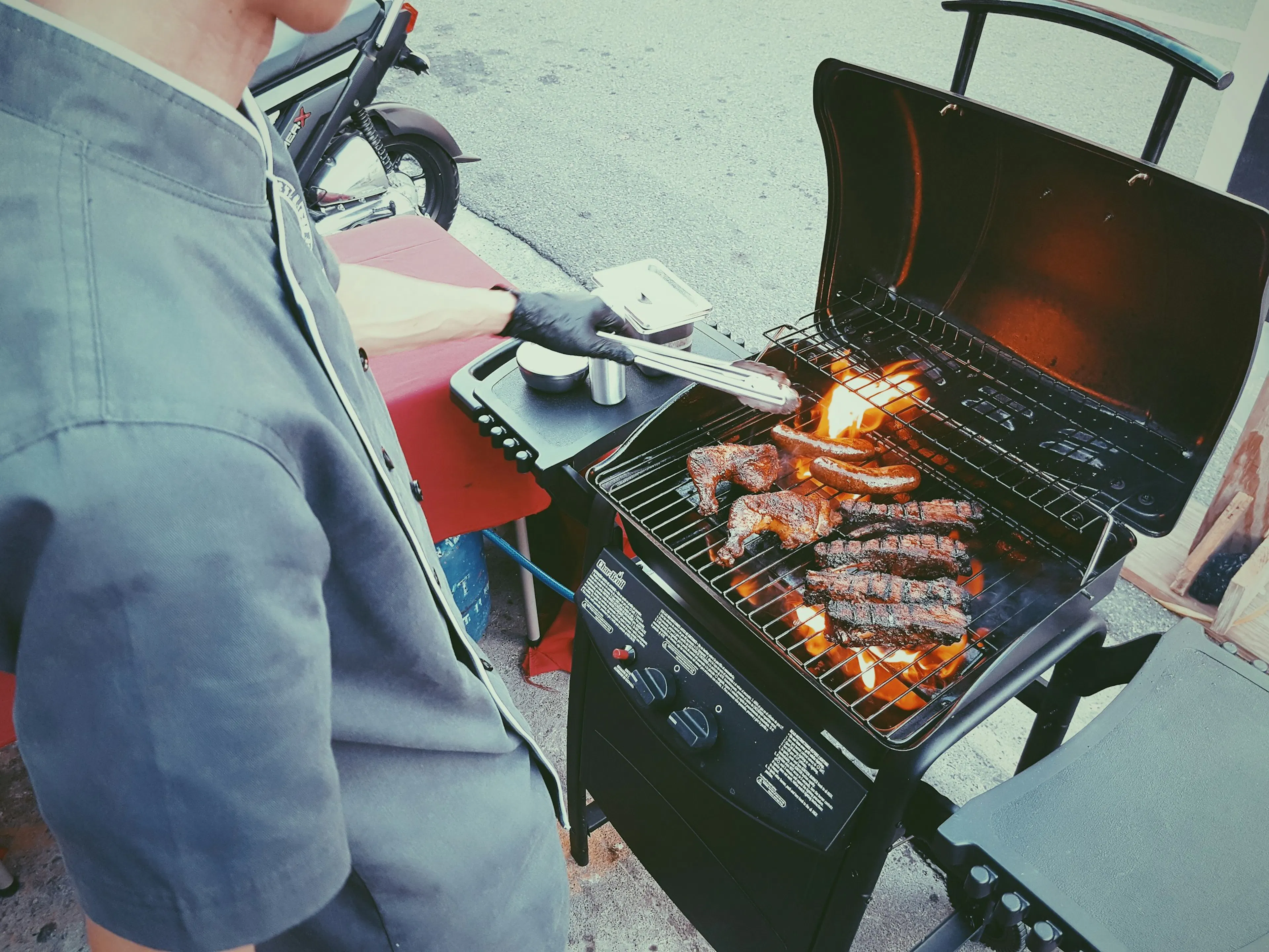 A person grilling both chicken and beef