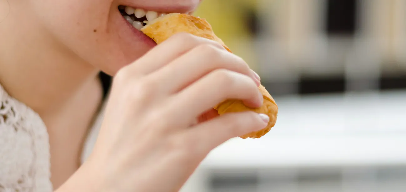 A lady eating a gluten heavy confectionary