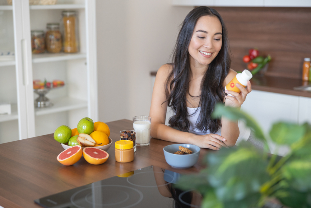 Lady looking at the pill container of a spermidine supplement