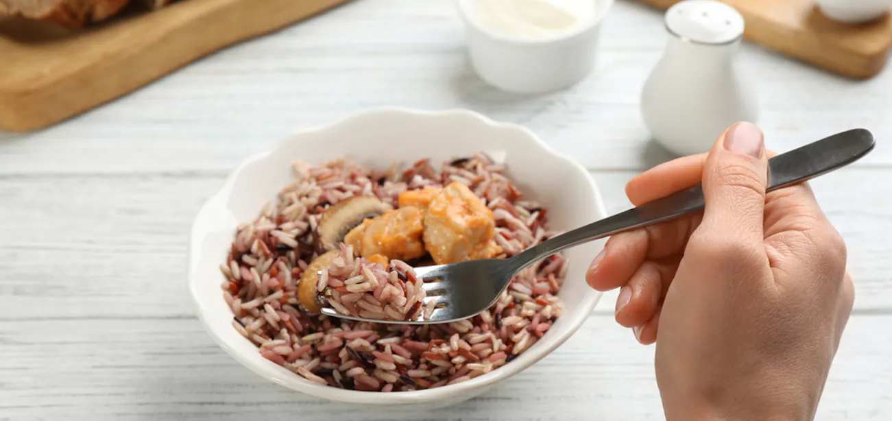 A person eating a meal of brown rice