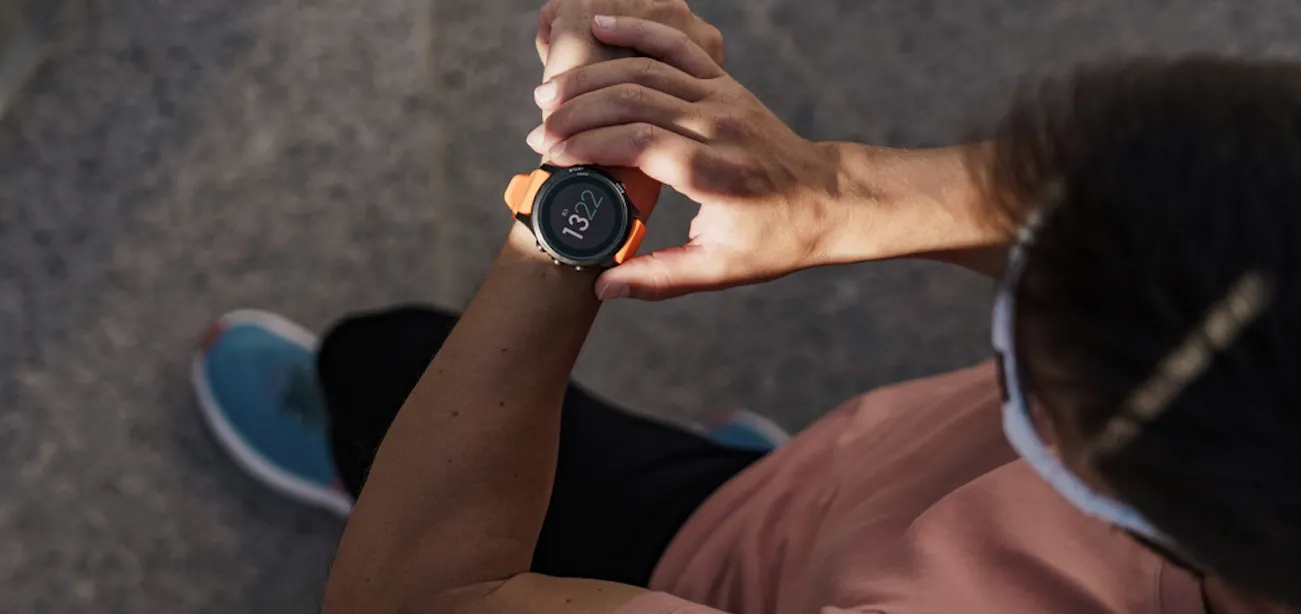 image of a person looking at their fitness tracker while exercising outdoors