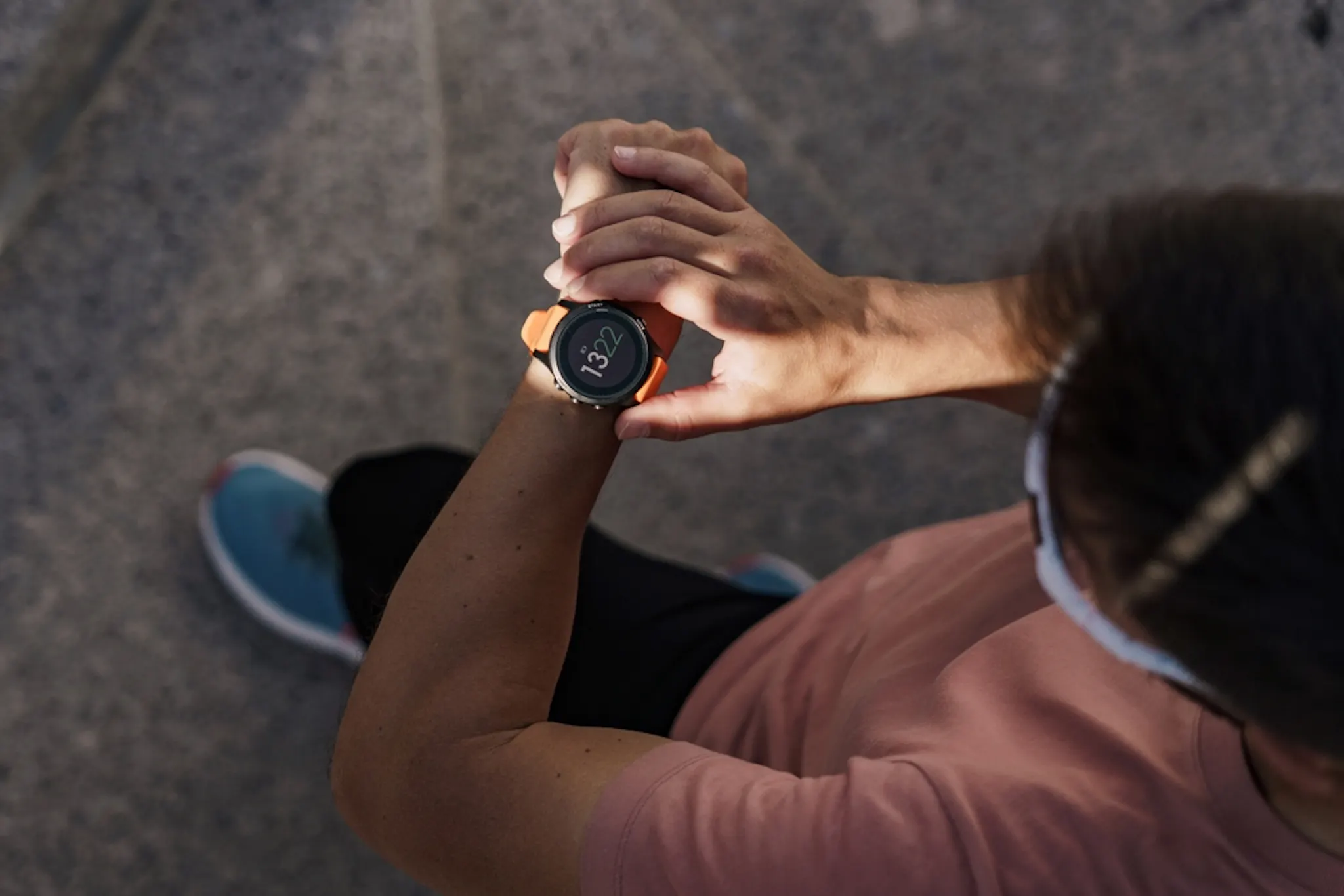 image of a person looking at their fitness tracker while exercising outdoors