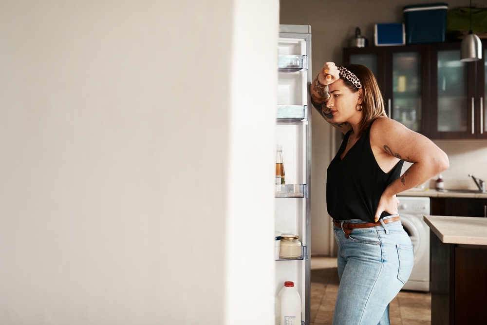 A lady staring inside the fridge