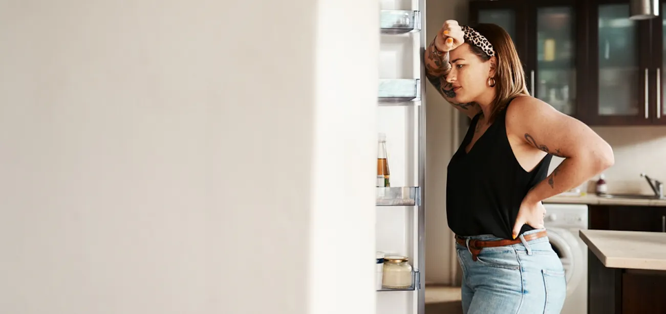 A lady staring inside the fridge