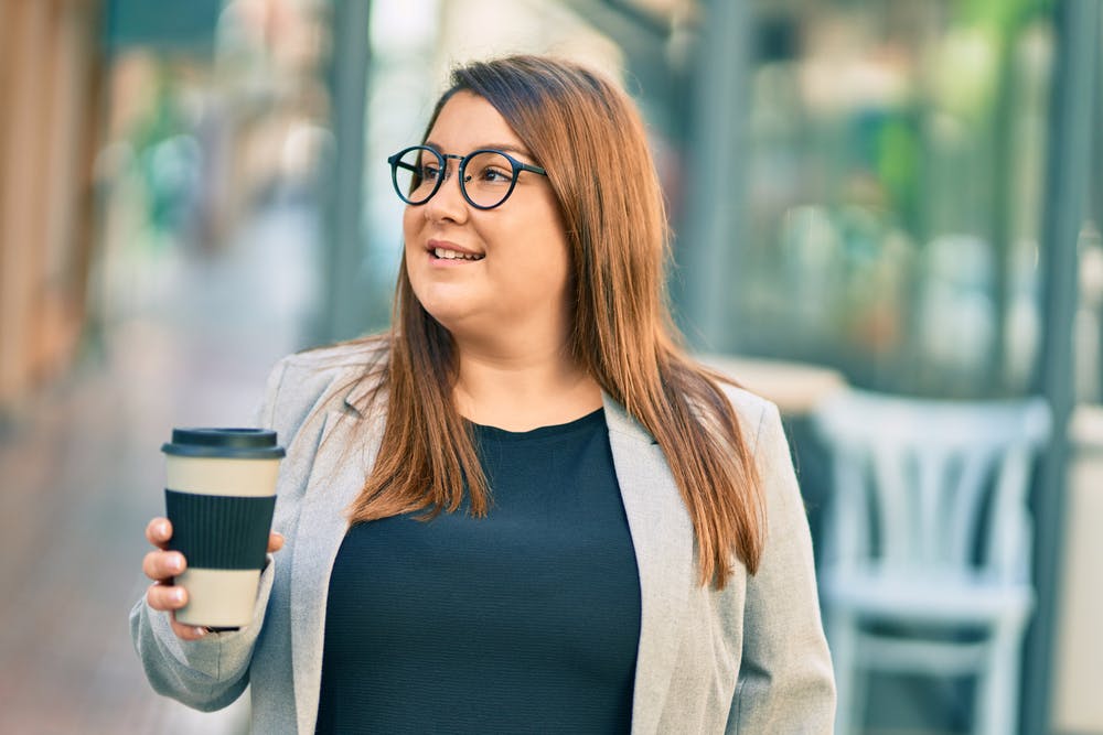 A lady drinking a cup of latte laced with sugar