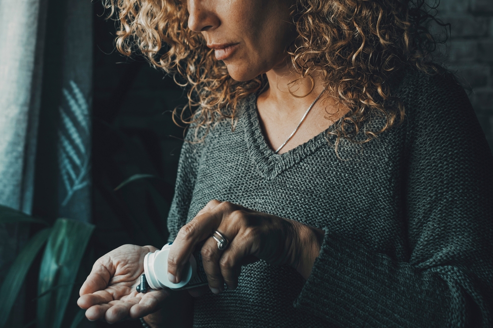 Image of a lady taking a supplement for hot flashes