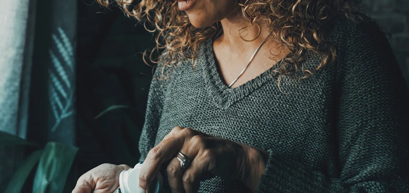 Image of a lady taking a supplement for hot flashes