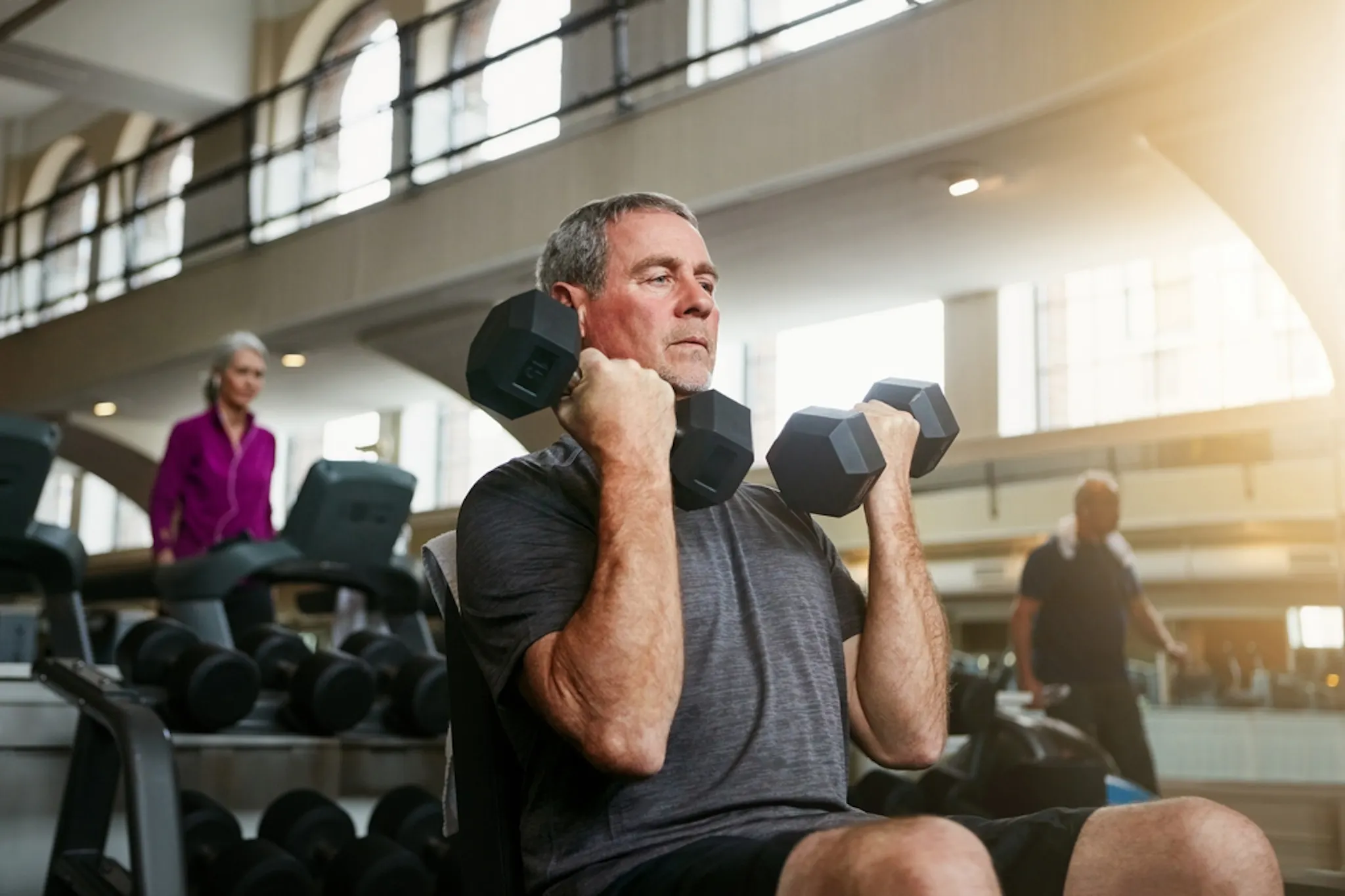 An image of an old man lifting weights for stronger bones