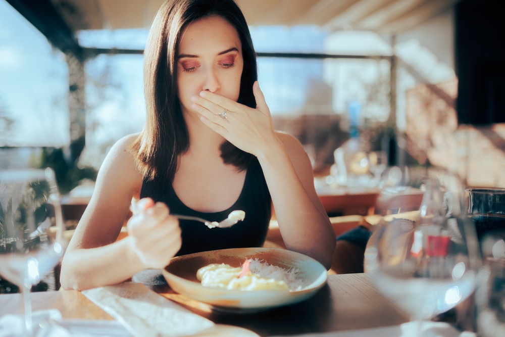 A lady having a sulphur burp while eating