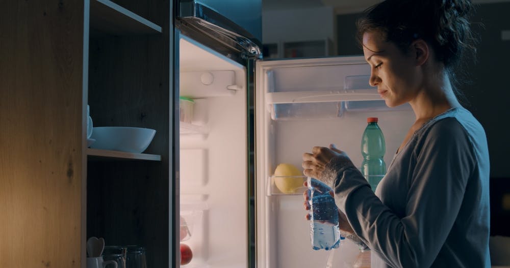 A person Drinking water at night to break late night eating habit