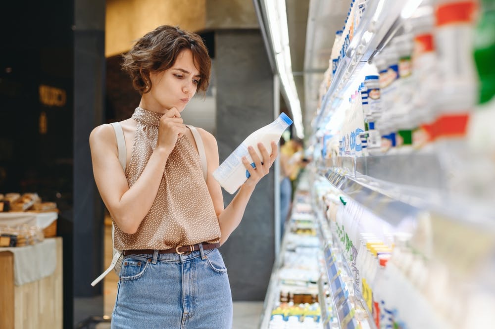 A lady checking a can of unsweetened coconut milk