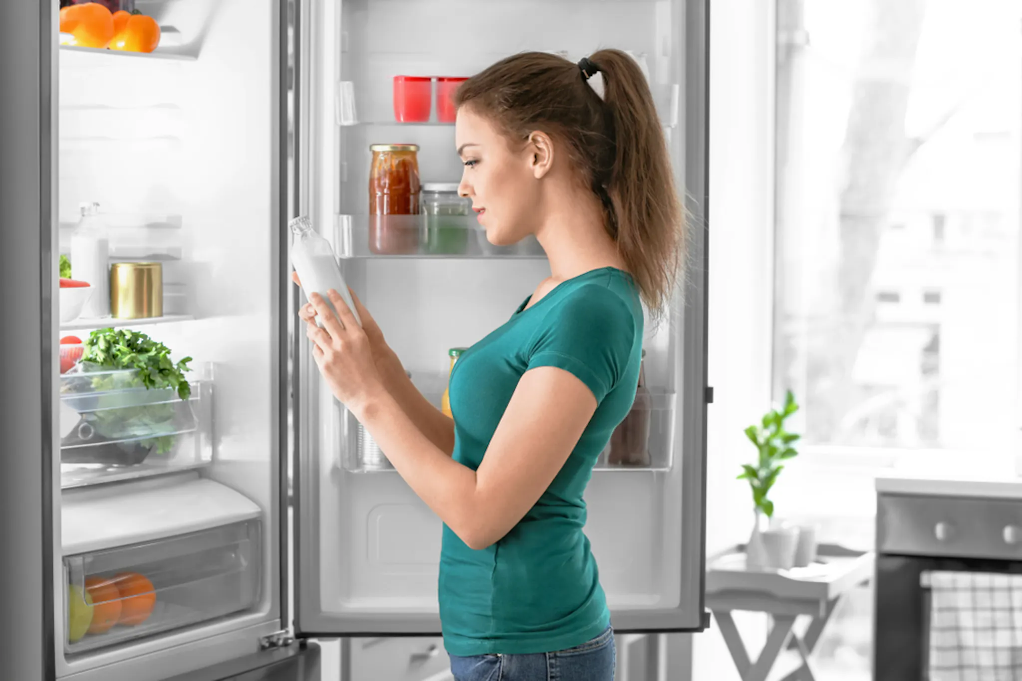A lady taking coconut milk from the fridge